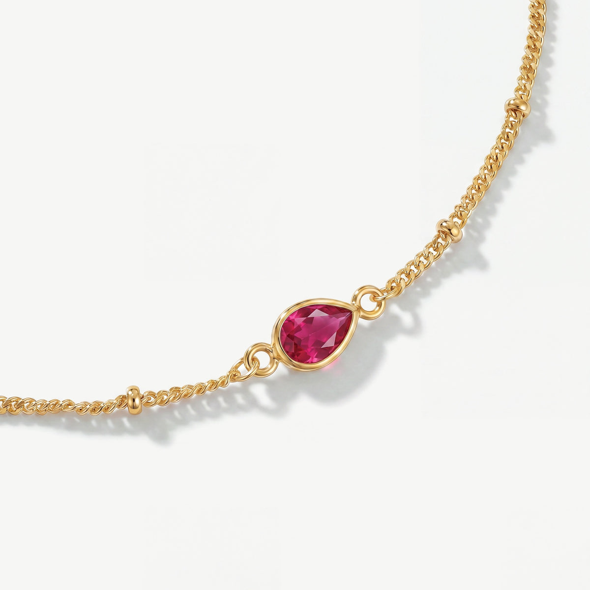 Genuine enhanced ruby teardrop gemstone on 18ct gold plated birthstone bracelet