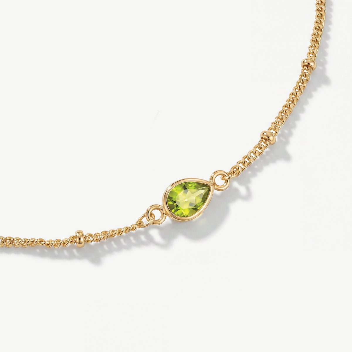 Genuine faceted peridot teardrop gemstone on 18ct gold plated birthstone bracelet